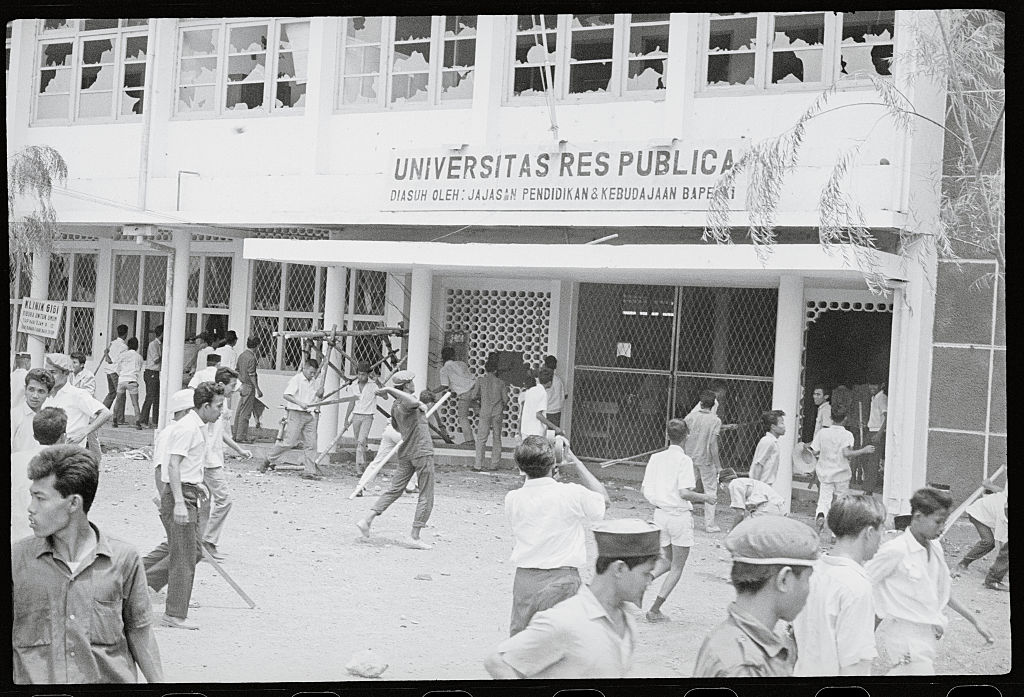 An anti-communist mob attacks the Res Publica University in Jakarta, Indonesia, 12 October 1965, after the university was said to have communist ties (Bettmann via Getty Images)