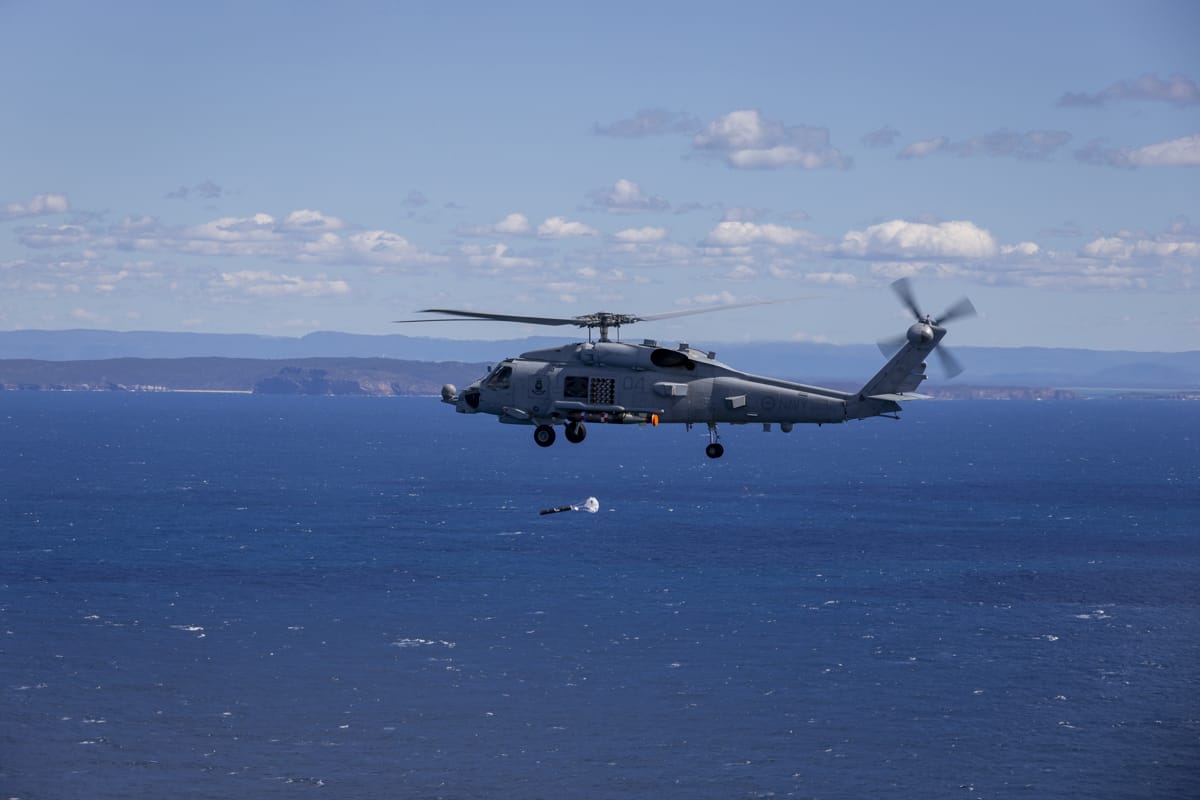 A Royal Australian Navy MH-60R Seahawk helicopter launches a sonobuoy during an anti-submarine warfare training in 2020 off the coast of Jervis Bay, New South Wales (Nadav Harel/Defence Department)