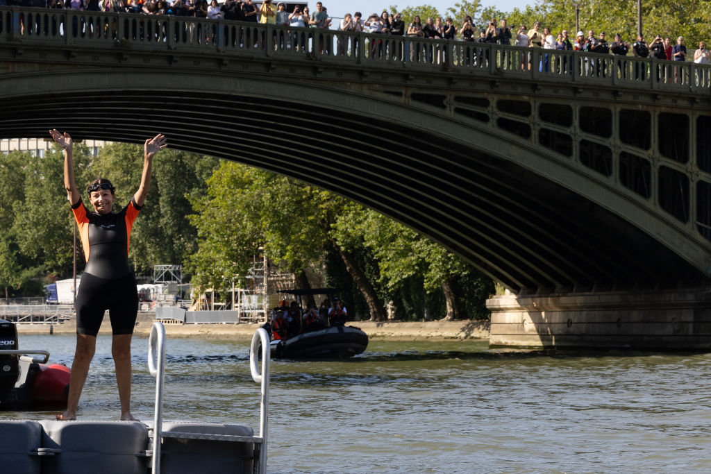 Paris Mayor Anne Hidalgo waves before swimming in the Seine on 17 July (Joel Saget/AFP via Getty Images)