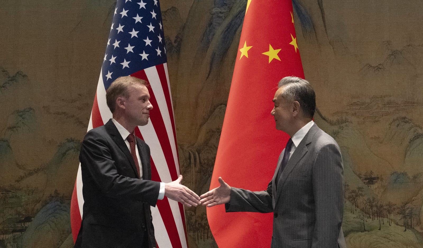 China's Foreign Minister Wang Yi (R) shakes hands with US National Security Advisor Jake Sullivan at Yanqi Lake in Beijing 27 August 2024 (Photo by Ng Han Guan