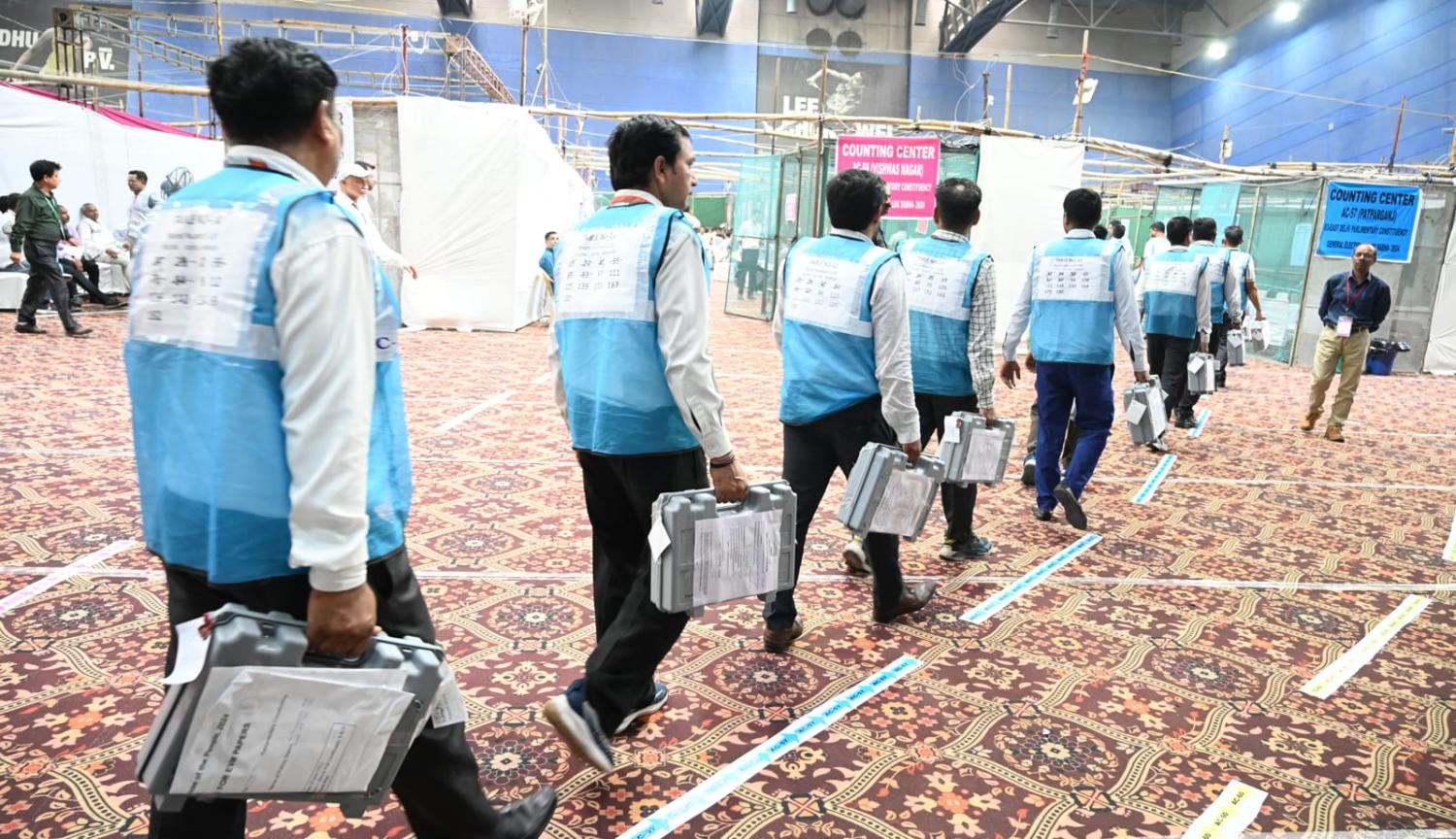 Election Commission officials carry in electronic voting machines for the tally at Akshardham counting center, 4 June 2024, in New Delhi, India (Sonu Mehta/Hindustan Times via Getty Images)