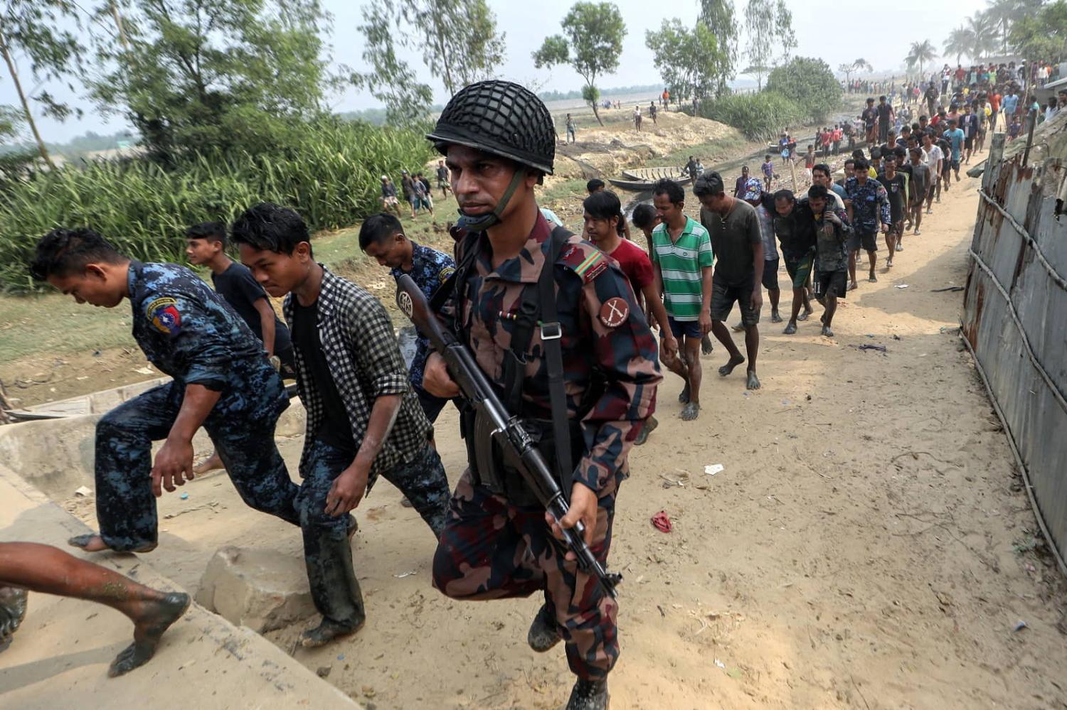 Border Guard Bangladesh personnel detain Myanmar Border Guard Police seeking refuge at Whaikhyang on the Bangladesh-Myanmar border, 7 February 2024 (AFP via Getty Images)