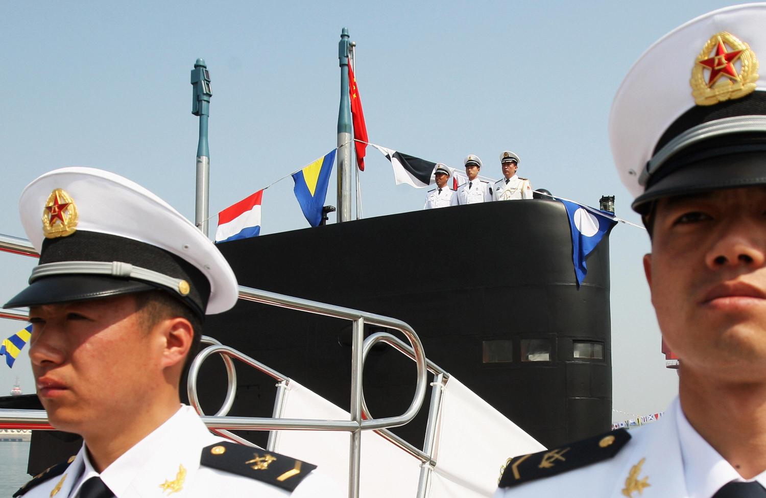 Naval personnel stand at attention as a Great Wall - 218 submarine docks at Qingdao Port on April 22, 2009. (Getty/Guang Niu)