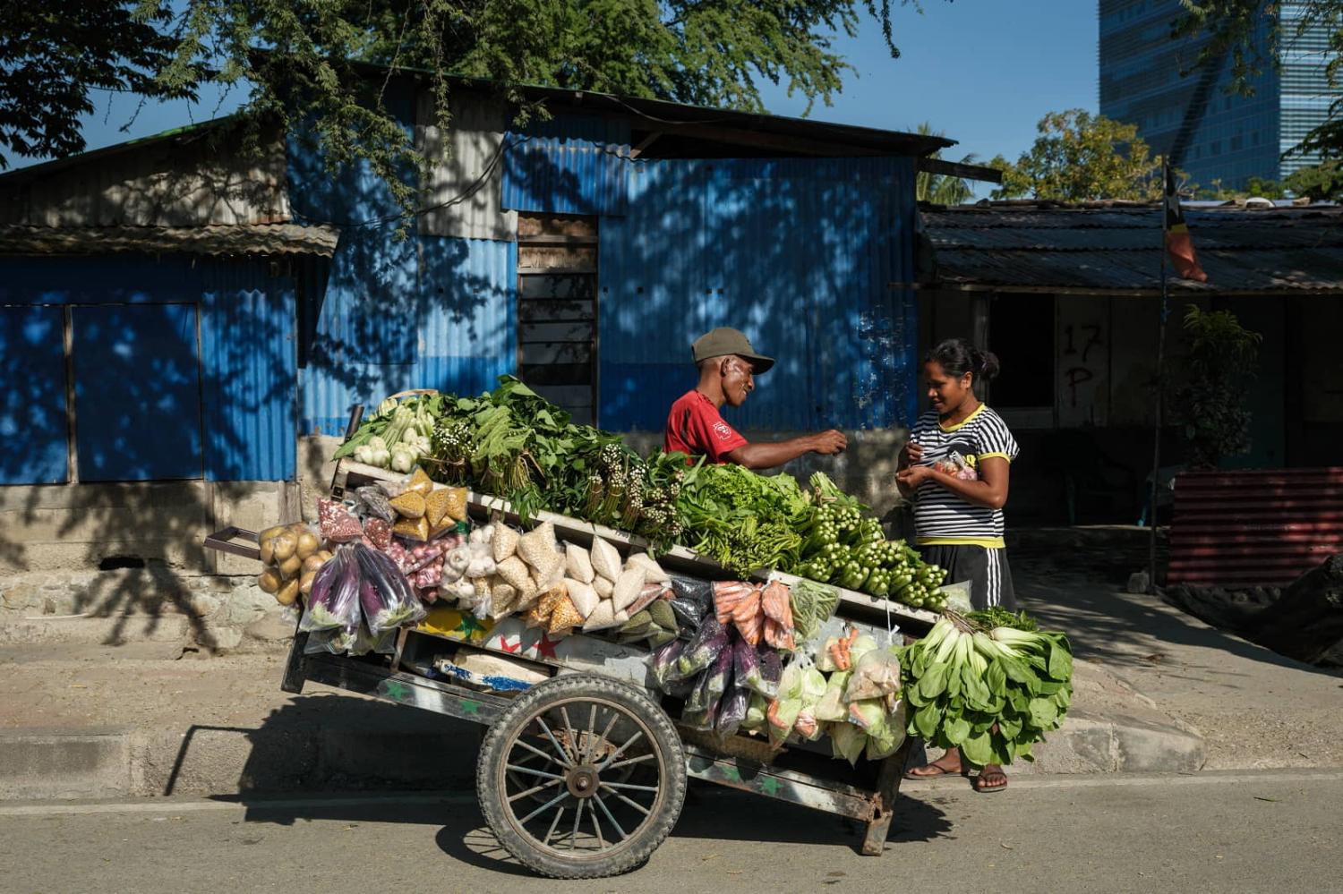 A woman buys vegetables from a street vendor in Dili, East Timor, 12 September 2024 (Yasuyoshi Chiba/AFP via Getty Images)