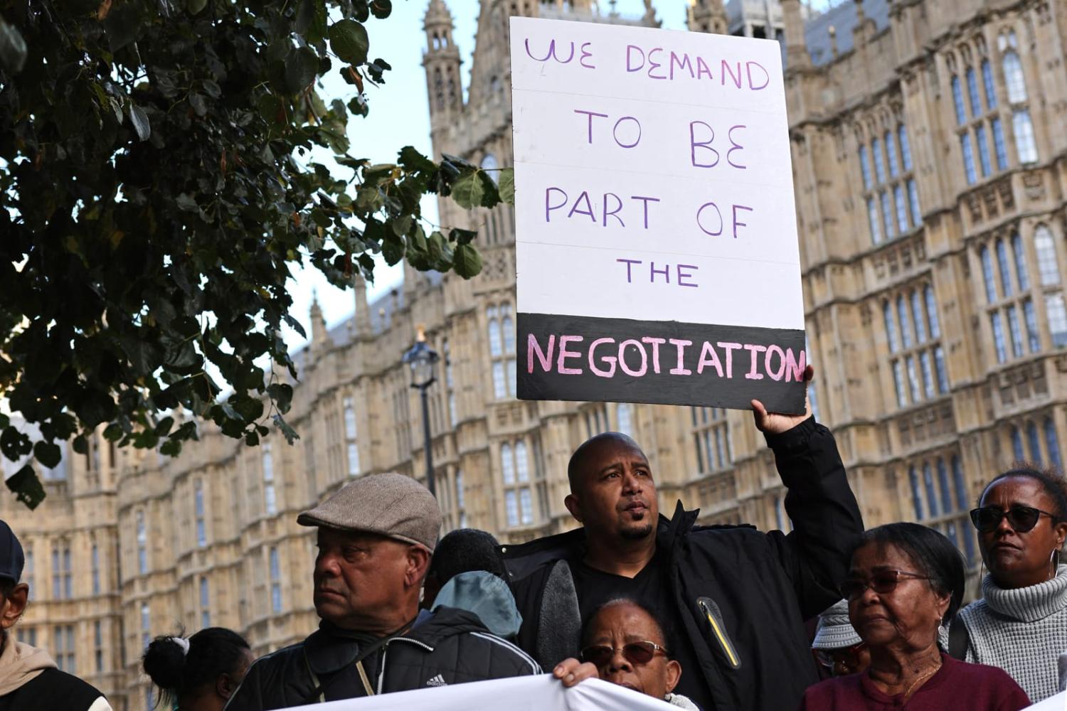 Members of the Chagossian community gather outside parliament in London on 7 October to protest the government's decision to hand the Chagos Islands over to Mauritius (Adrian Dennis/AFP via Getty Images)