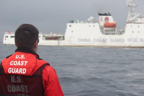 A crew member of the USCGC Alex Haley watches a China Coast Guard vessel, 21 June 2018. (Coast Guard News/Flickr)