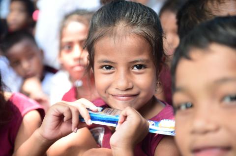 An I-Kiribati child holds her toothbrush during a Pacific Partnership dental outreach program run by Australia, New Zealand and the United States held at the Dai Nippon Primary School in Betio, Tarawa (Jonathan R. Kulp/US Navy)