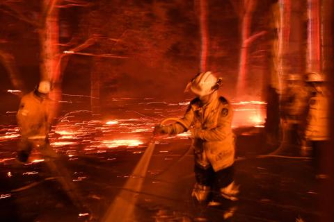 Firefighters battle against bushfires around the town of Nowra in the Australian state of New South Wales on New Year's Eve, 2019 (Saeed Khan/AFP via Getty Images)